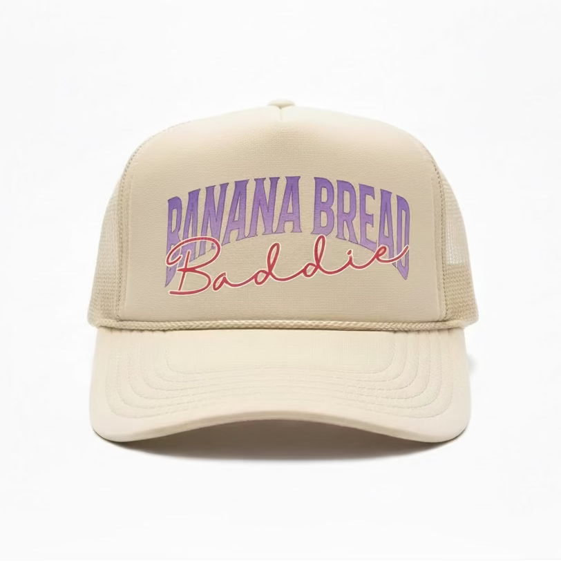 Khaki cap with 'Banana Bread Baddie' text in purple and pink on a white background