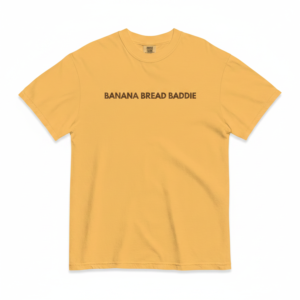 Yellow t-shirt with 'Banana Bread Baddie' text on a white background