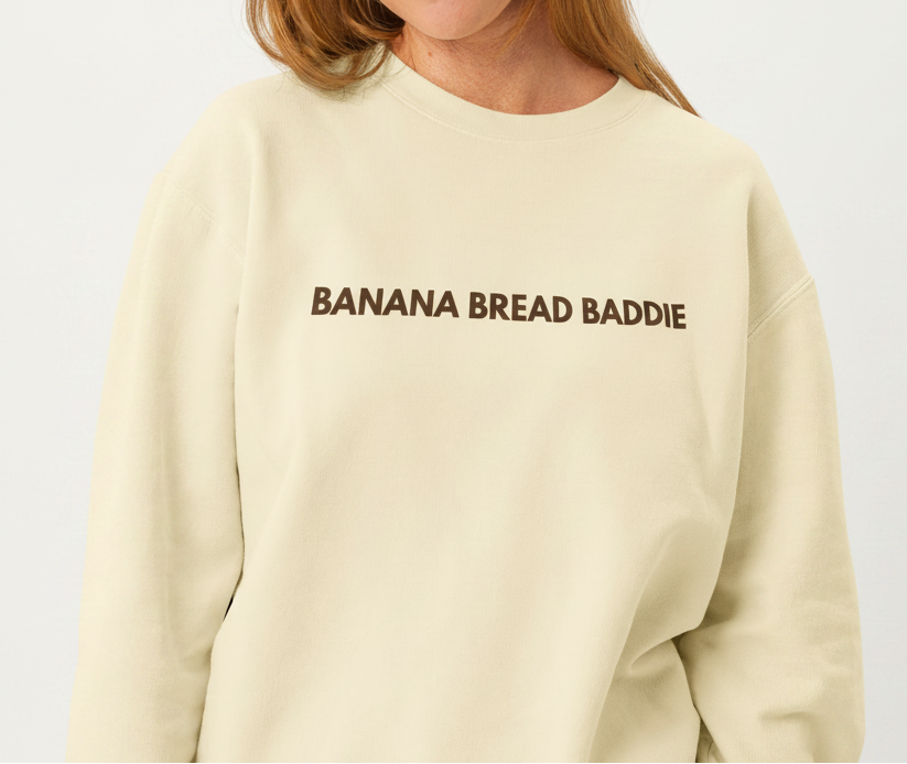 Woman wearing a beige sweatshirt with a espresso logo on a white background