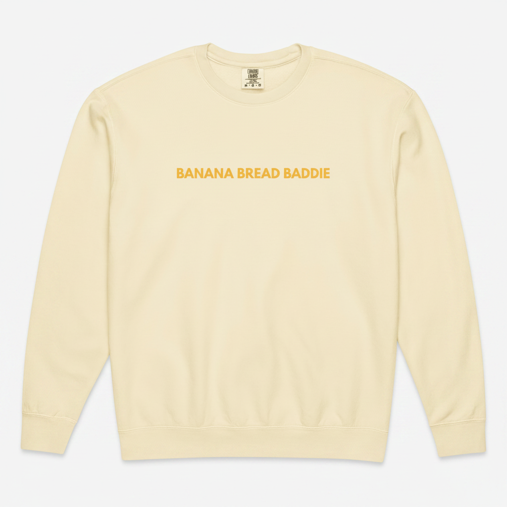 Beige sweatshirt with 'Banana Bread Baddie' text on a white background